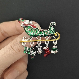 Detail of Christmas sleigh brooch with enamel charms like candy cane and stocking