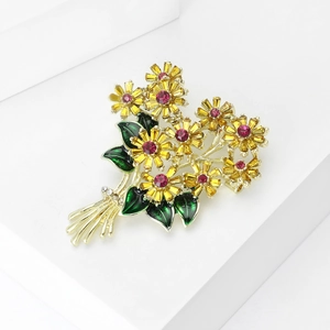 Detail of flower bouquet brooch with yellow petals and crystals on golden metal base