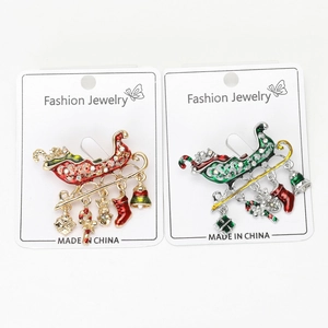 Detail of enamel Christmas sleigh brooches with dangling bells and festive charms