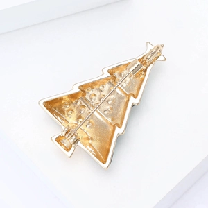Detail view of the golden Christmas tree brooch back with safety pin and textured metal