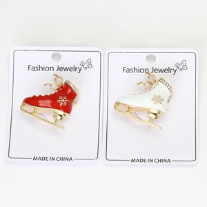 Detail of crystal enamel ice skate brooches with gold snowflake charms for Christmas