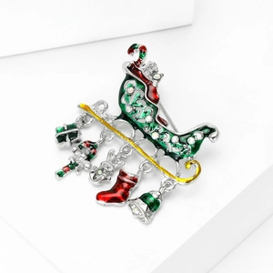 Detailed close-up of Christmas sleigh brooch with festive charms on white background