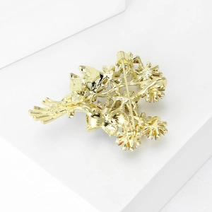 Elegant gold daisy bouquet brooch with secure pin clasp shown on a white pedestal