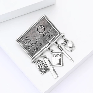 Detailed view of silver math brooch with chalkboard engraving and stationery pendants