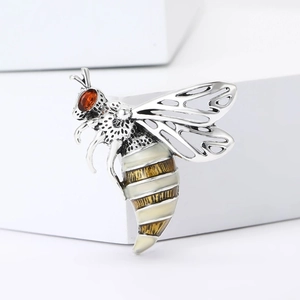Exquisite honey bee brooch with red zircon head and hollow wings on a white pedestal