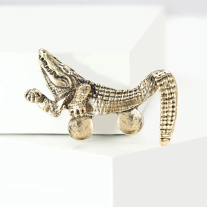 Vintage gold alloy crocodile brooch with rhinestone scales on white display stand