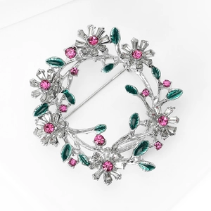 Makroaufnahme der Kristall-Blumenkranz-Brosche mit rosa Strass und grünen Blättern