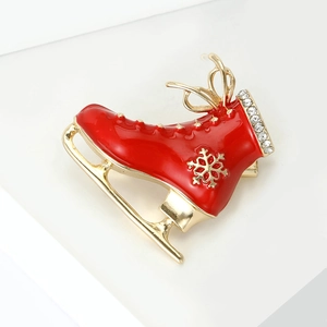 Detail of Christmas ice skate brooch with red enamel, gold snowflakes and white rhinestones