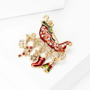 Close-up of a festive Christmas sleigh brooch with colorful enamel and dangling charms