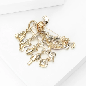 Back view of a gold Christmas charm brooch with pins, holiday sleigh style charms