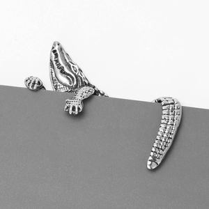 Macro view of vintage silver crocodile lapel pin with detailed scales and texture