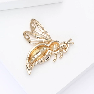 Detail view of the golden bee brooch back showing the pin closure and hollowed out wings