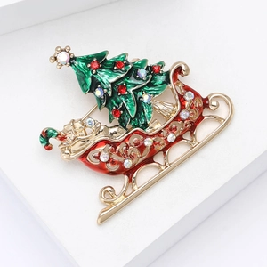 Christmas tree and red sleigh brooch with colorful rhinestones on a white podium