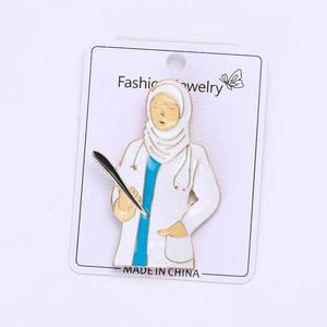 Detailed macro view of a creative alloy enamel pin depicting a female doctor in a hijab