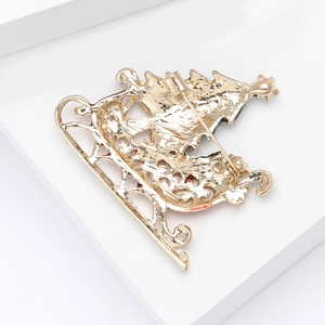 Macro detail showing the sturdy safety pin clasp and golden alloy back of the Christmas brooch