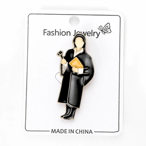 Detailed close-up of a metal lawyer brooch with black gown on a white product card