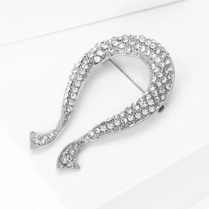 Détail macro d'une broche en U argentée avec strass scintillants et épingle de sûreté