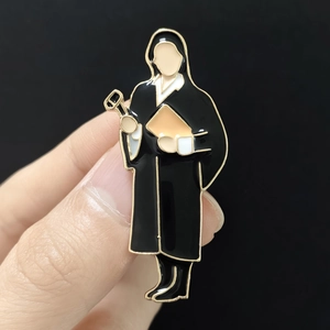 Macro shot of judge enamel brooch with gold-plated metal finish on a black background