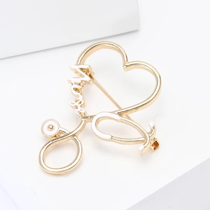 Detailed view of a golden stethoscope enamel brooch with a heart and Nurse lettering