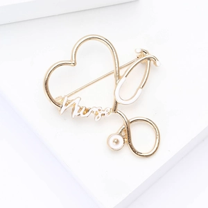 Macro detail of gold-plated stethoscope heart brooch with white enamel Nurse lettering