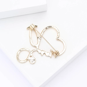 Detailed view of the gold stethoscope heart brooch reverse side with secure safety pin clasp