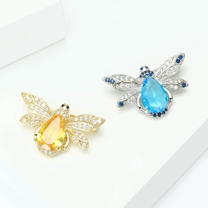 Broches abeilles vintage avec cristaux goutte d'eau jaunes et bleus sur support blanc