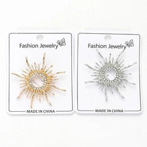 Detail of sunburst brooch pins in gold and silver finish with sparkling rhinestone inlay