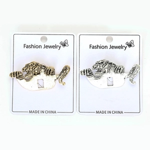 Detailed view of antique gold and silver tiger brooches on display cards for suits