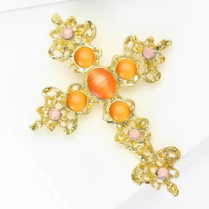 Détail de la broche croix avec filigrane doré, pierre œil-de-chat orange et strass