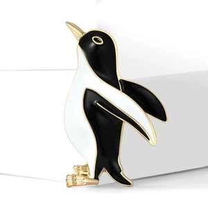 Broche pingouin en émail noir et blanc avec des accents métalliques dorés élégants