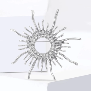 Exquisite silver sunburst alloy brooch with sparkling rhinestones on a white stand