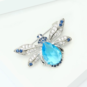 Détail d'une broche abeille vintage avec cristal bleu et strass brillants décoratifs