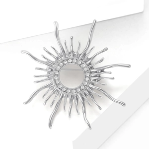 Detailed macro of silver sunburst brooch with rhinestones and elegant rays for suits