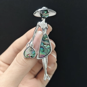 Détail d'une broche femme élégante avec incrustation de nacre d'abalone sur métal argenté