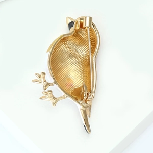 Detailed back view of the bird brooch showing gold-plated alloy and secure pin closure