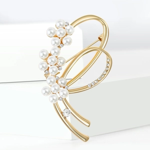 Broche nœud élégante en alliage doré avec perles et strass sur fond blanc minimaliste