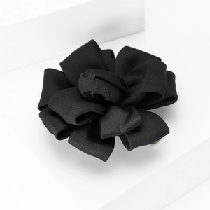 Detailed view of handmade black fabric floral brooch with textured multi-layer petal design