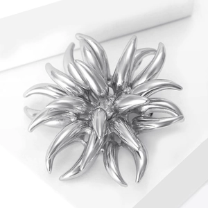 Detailed close-up of a silver firework-shaped dahlia brooch with polished petal textures