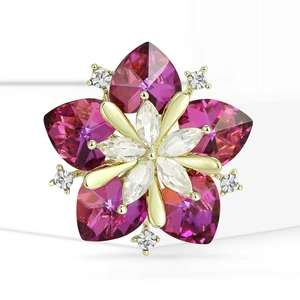 Macro detail of sunflower brooch featuring pink heart gems and crystal center on gold base