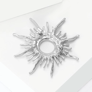 Macro shot of silver sunburst brooch back showing secure rotary safety pin clasp