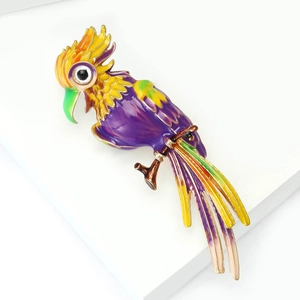 Macro shot of colorful enamel parrot brooch with gold-tone edges on white platform