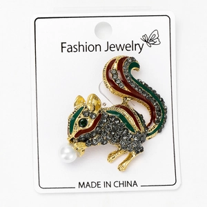 Detail of squirrel brooch with black rhinestones, enamel stripes, and a faux pearl