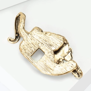 Macro view of vintage tiger brooch showing detailed gold brushed texture on metal alloy surface