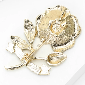 Detailopname van de gouden bloemspeld achterkant met stabiele pin en metalen textuur