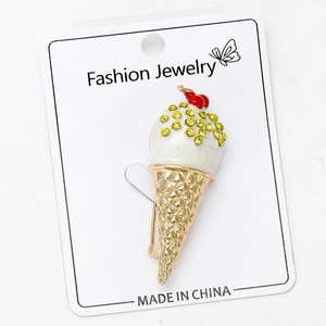 Detail view of ice cream brooch with yellow rhinestones and white enamel finish