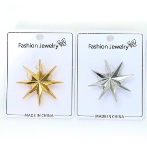 Detail of gold and silver eight-pointed star alloy brooches on fashion jewelry cards
