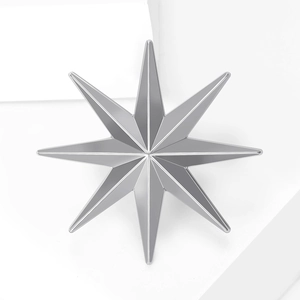 Minimalist 3D silver star brooch with polished metallic finish on white geometric pedestal