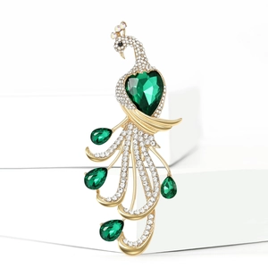 Macro detail of luxury peacock brooch with sparkling green crystals and gold plating