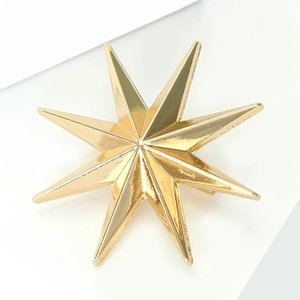 Macro detail of glossy golden eight-pointed star brooch with polished metallic surface