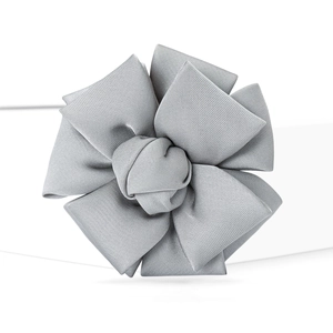 Detail of silver gray fabric flower brooch with multi-layered pleated petals and fine texture